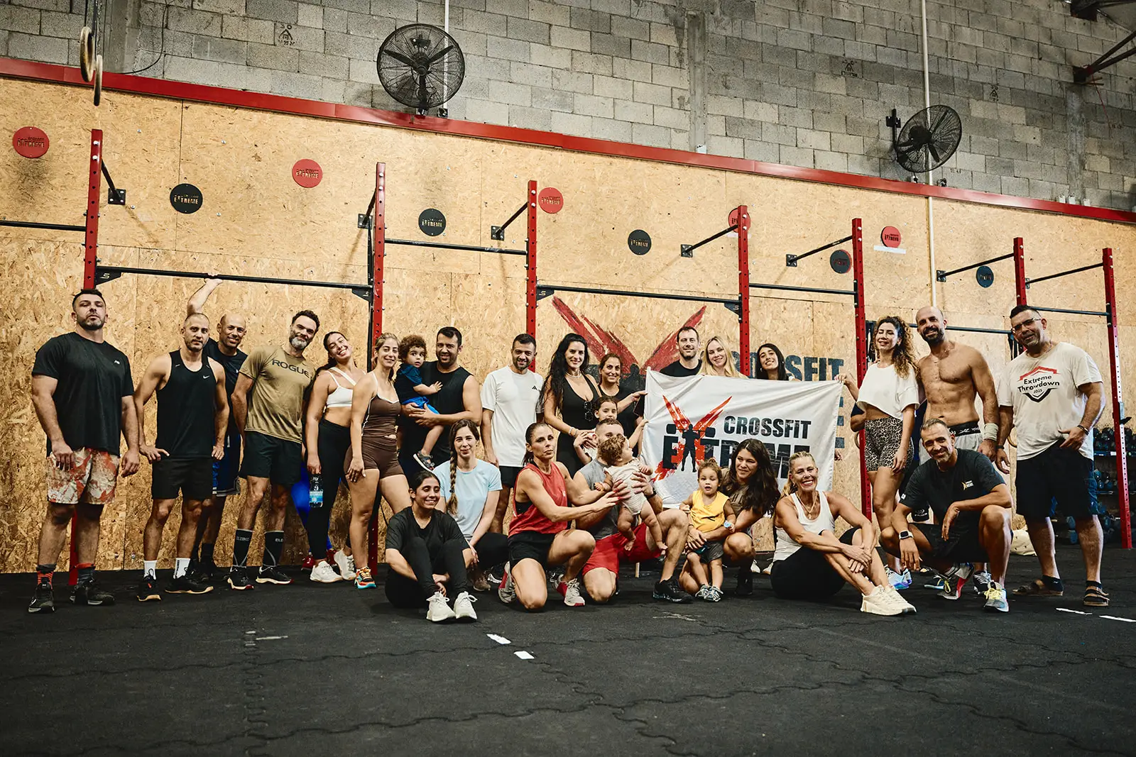 תמונה קבוצתית של קהילת CrossFit Extreme עם דגל המועדון