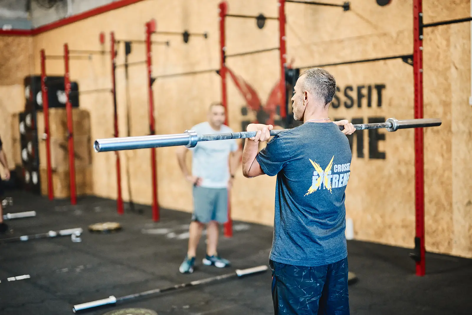 מאמן מדגים אחיזת מוט מול מתאמנים במועדון CrossFit Extreme
